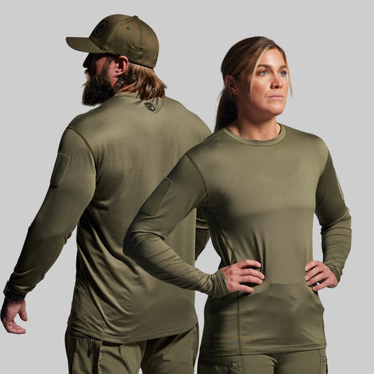 Two people wearing olive green long-sleeve shirts and pants on a gray background