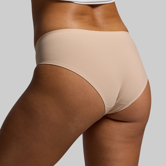 Beige underwear worn by a person on a plain background