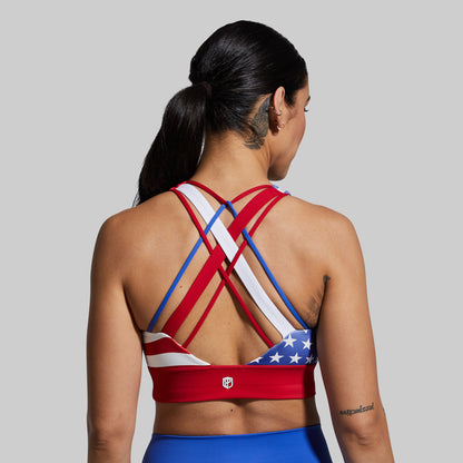 Person wearing a sports bra with American flag design on a plain background
