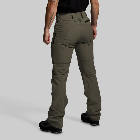 Person wearing olive green outdoor pants on a gray background