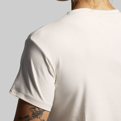 Person wearing a beige t-shirt with a plain background