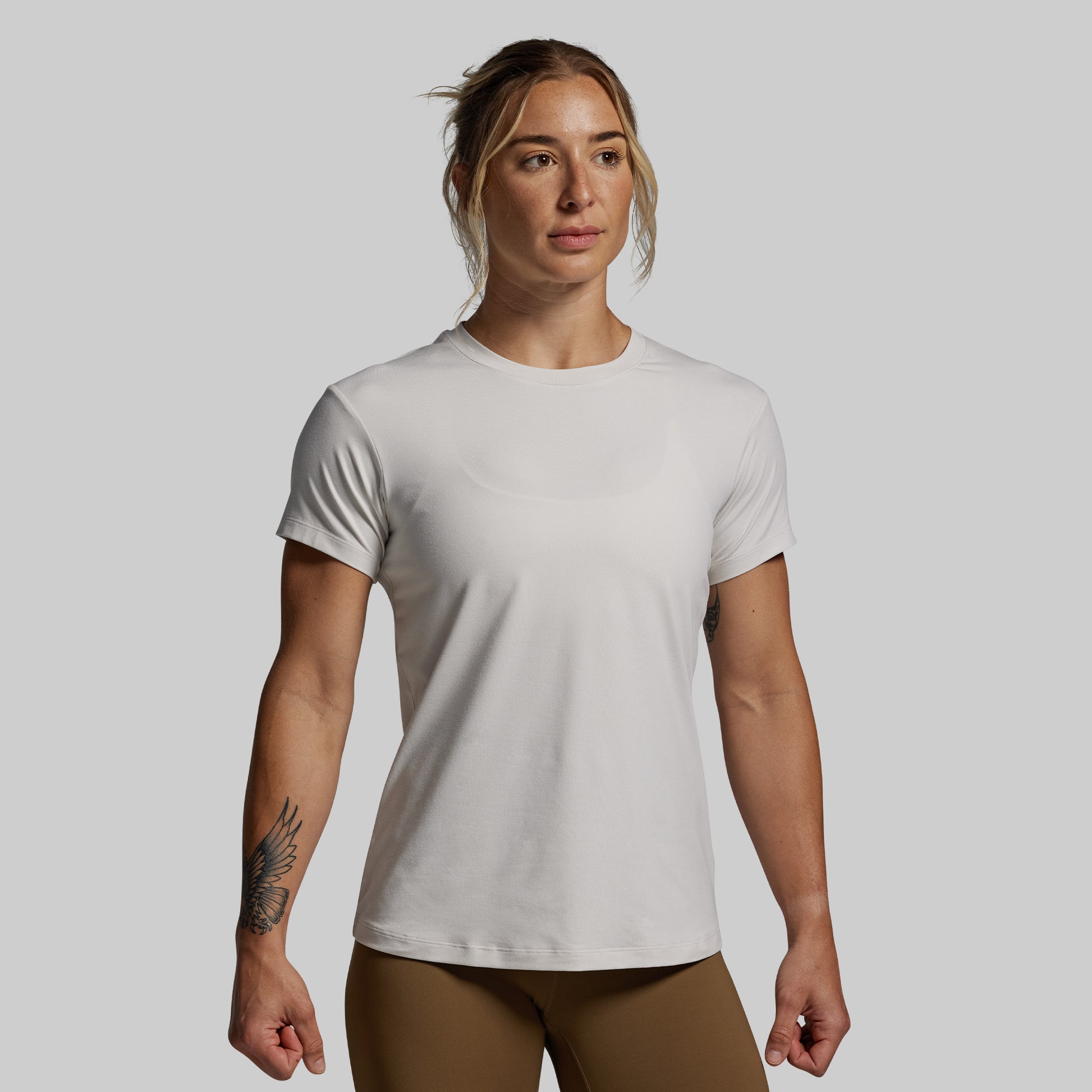 Woman wearing a plain white t-shirt against a gray background