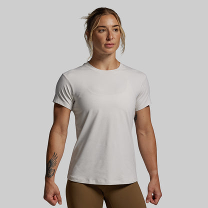 Woman wearing a plain white t-shirt against a gray background