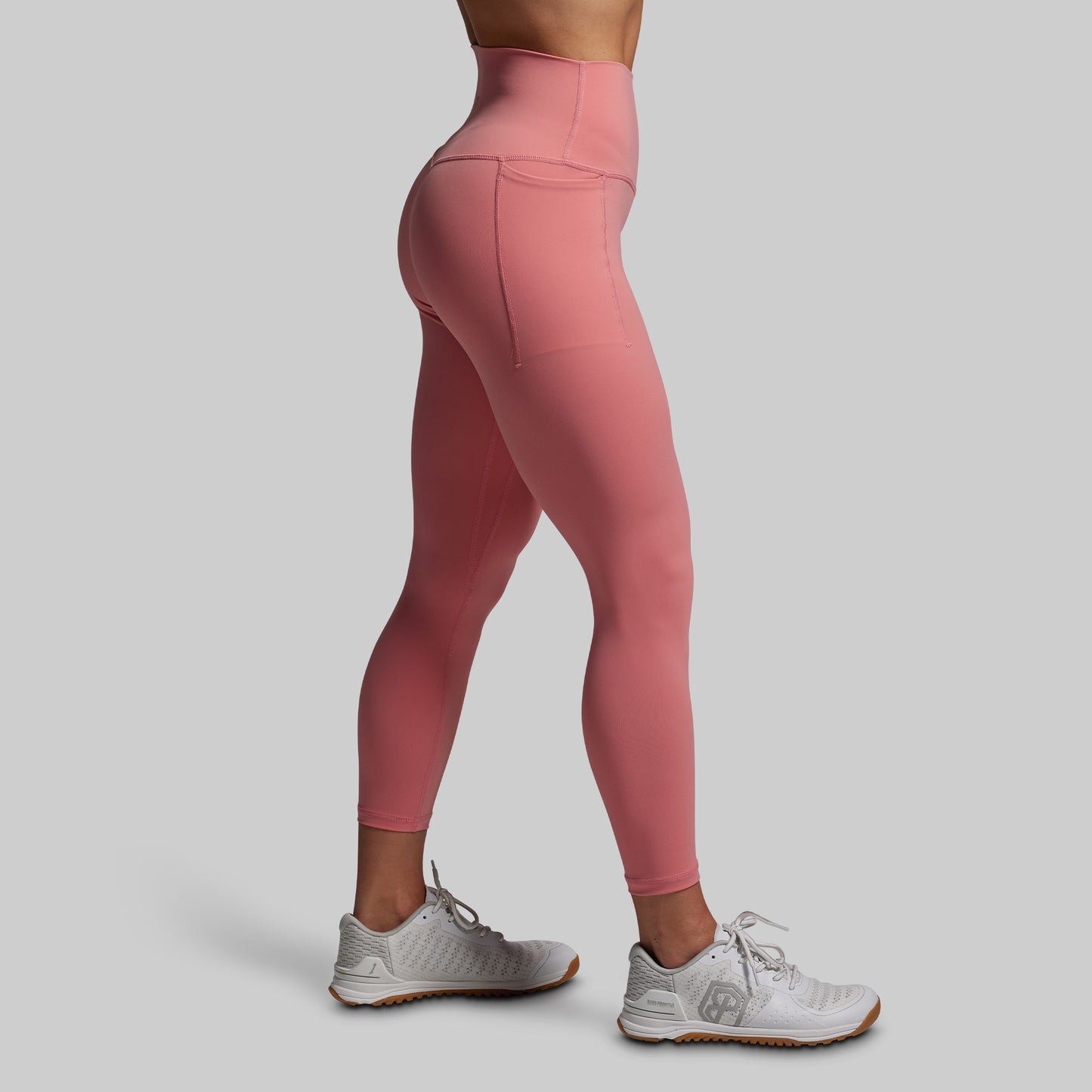 Pink leggings worn by a person on a gray background