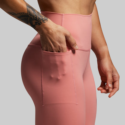 Person wearing a pink athletic outfit with a gray background