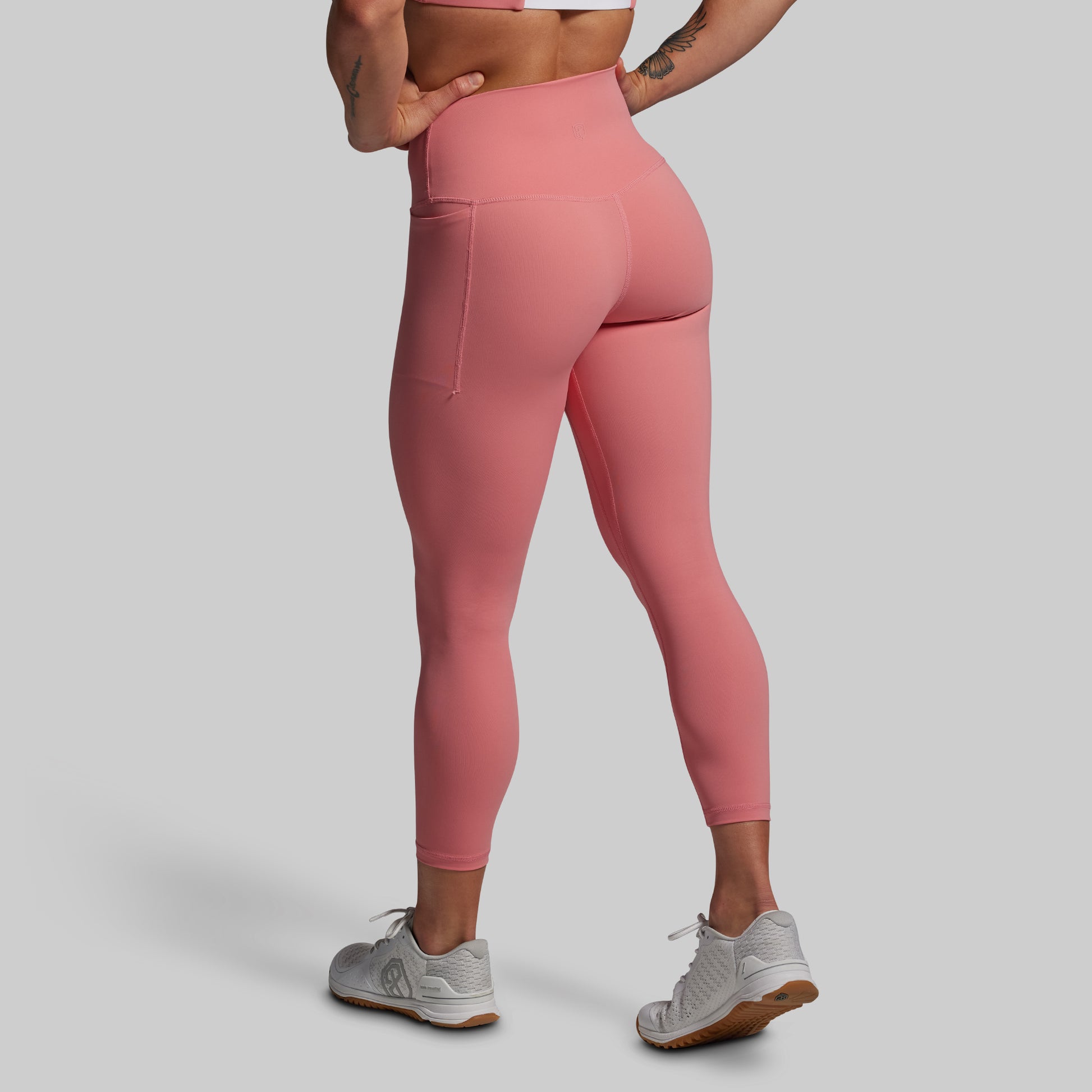 Person wearing pink leggings on a plain background