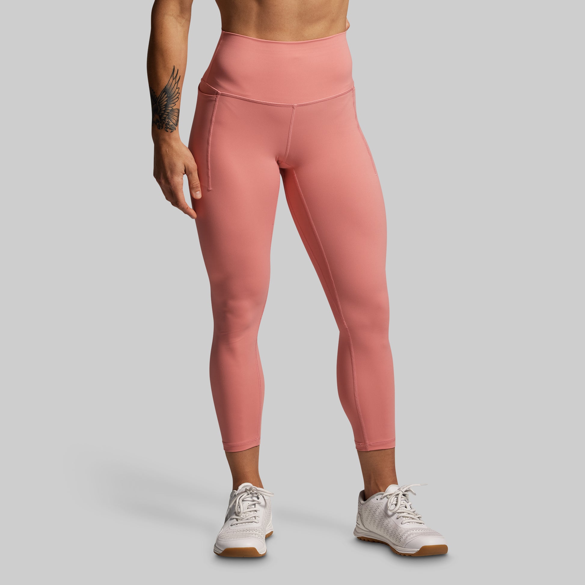 Person wearing pink leggings on a gray background
