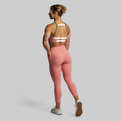 Woman wearing a pink athletic outfit on a gray background