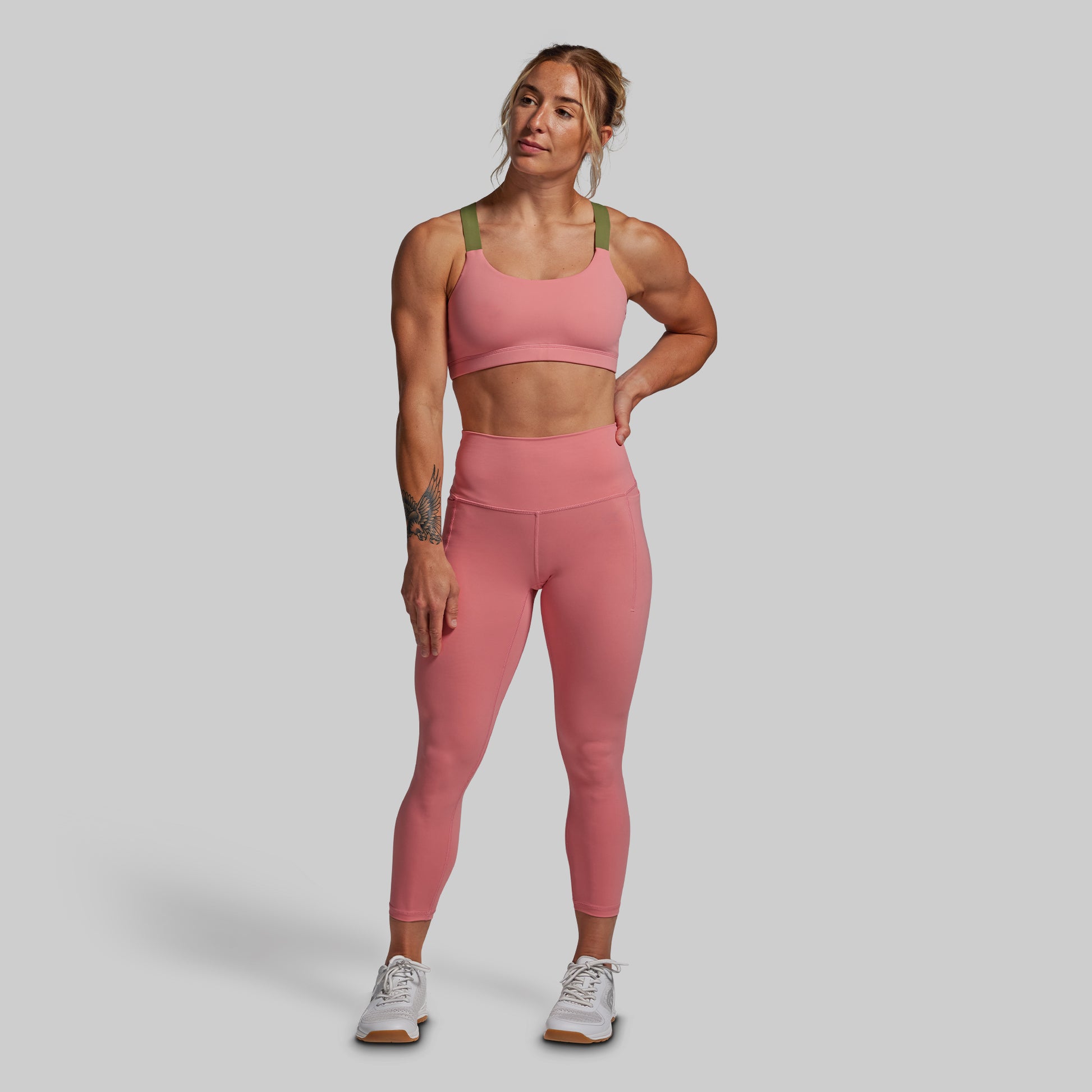 Woman wearing a pink athletic outfit on a gray background
