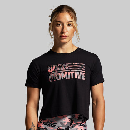 Person wearing a black t-shirt with 'Born Primitive' text on a gray background