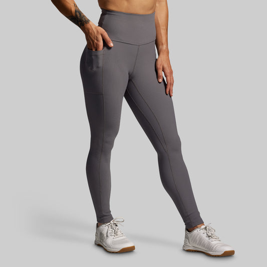 Person wearing gray leggings on a plain background