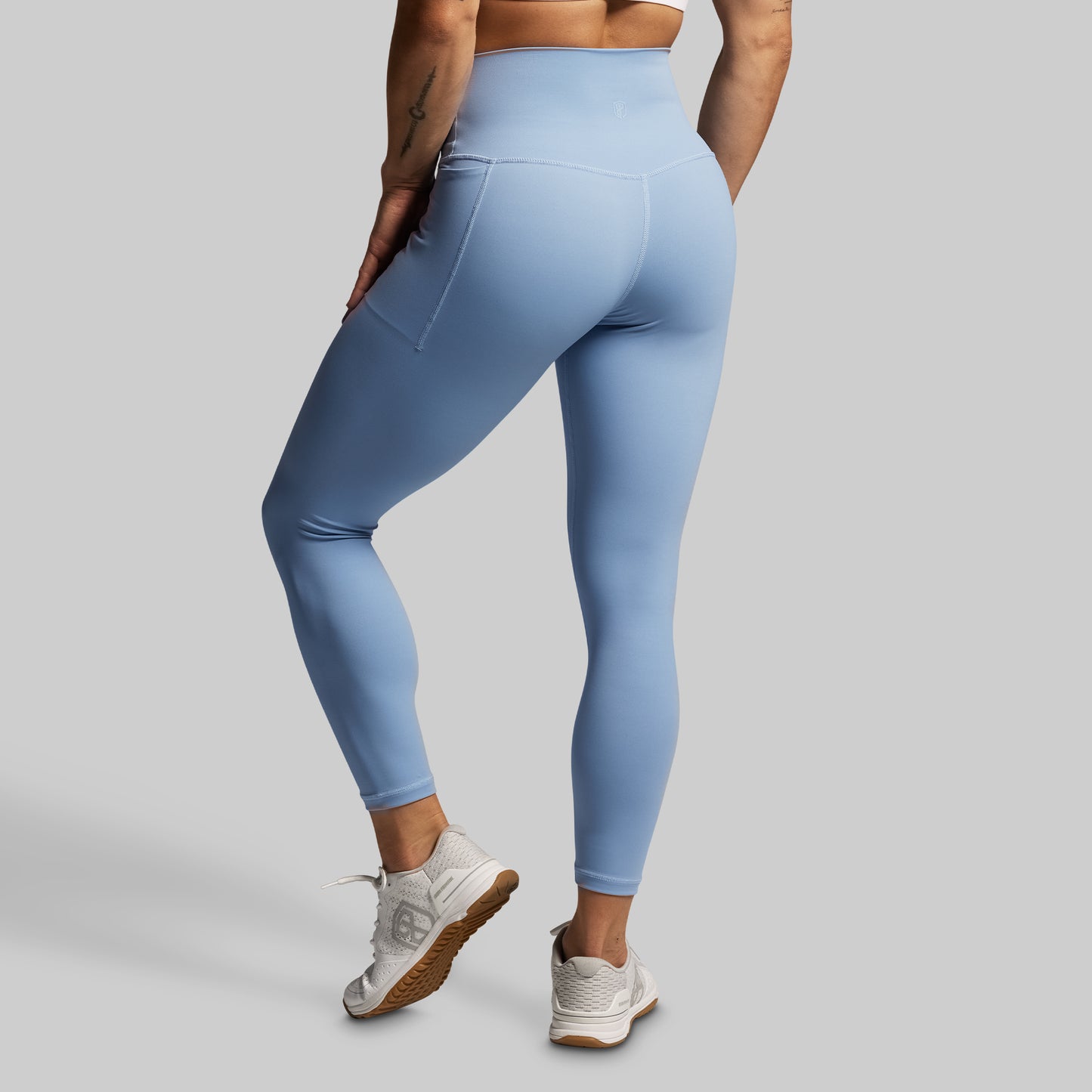 Light blue leggings worn by a person on a gray background