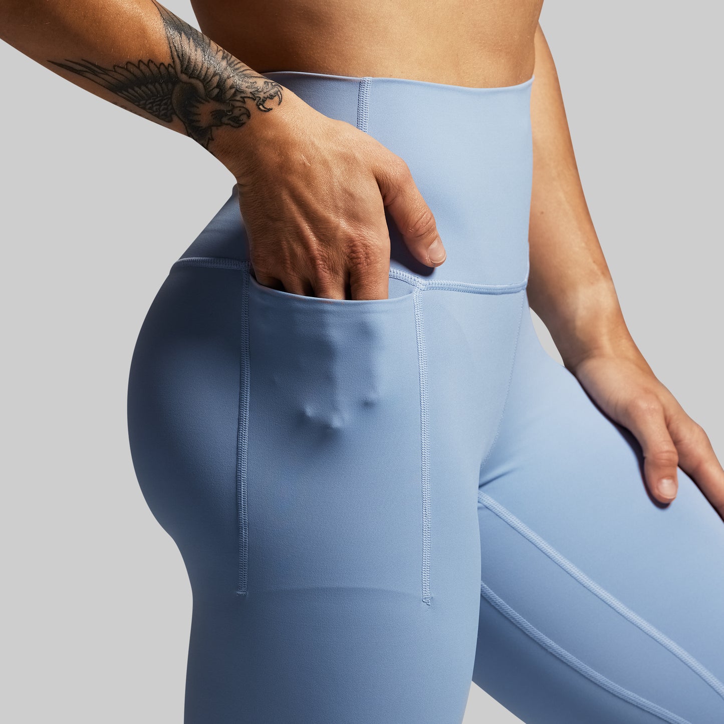 Light blue leggings worn by a person on a gray background
