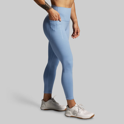 Person wearing light blue leggings on a gray background