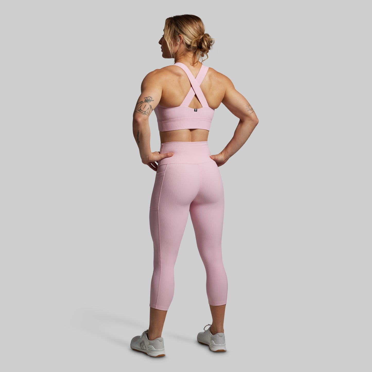 Woman wearing a pink athletic outfit from the back.