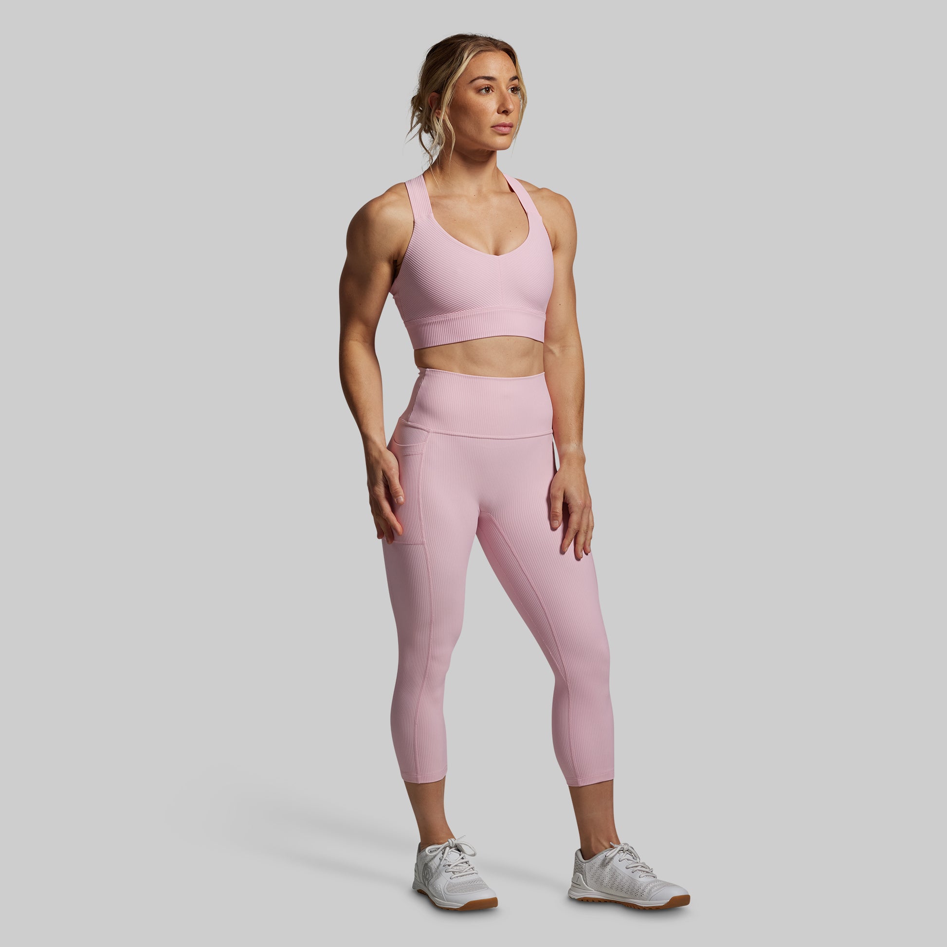 Woman in pink athletic outfit on a gray background