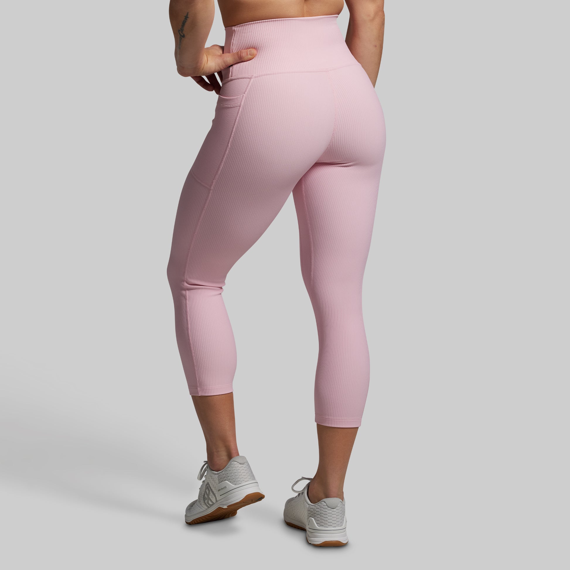 Pink leggings worn by a person on a gray background