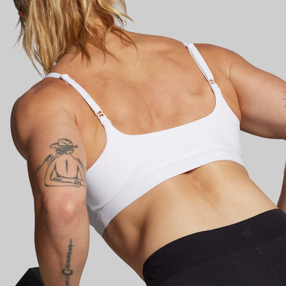 Person wearing a white sports bra from the back.