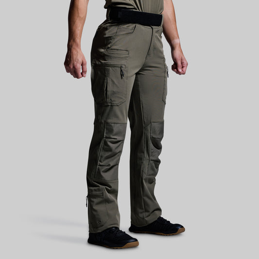 Person wearing olive green tactical pants on a light gray background