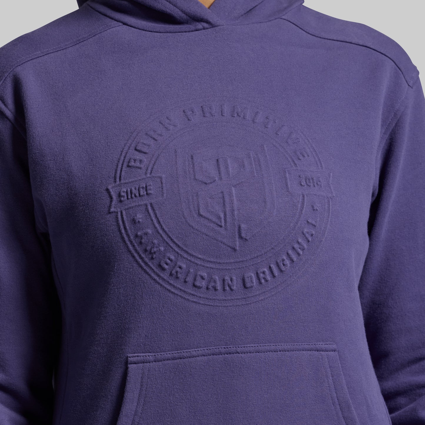 Purple hoodie with a logo on the chest against a gray background