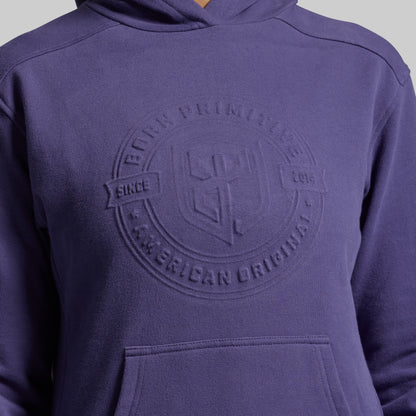 Purple hoodie with a logo on the chest against a gray background