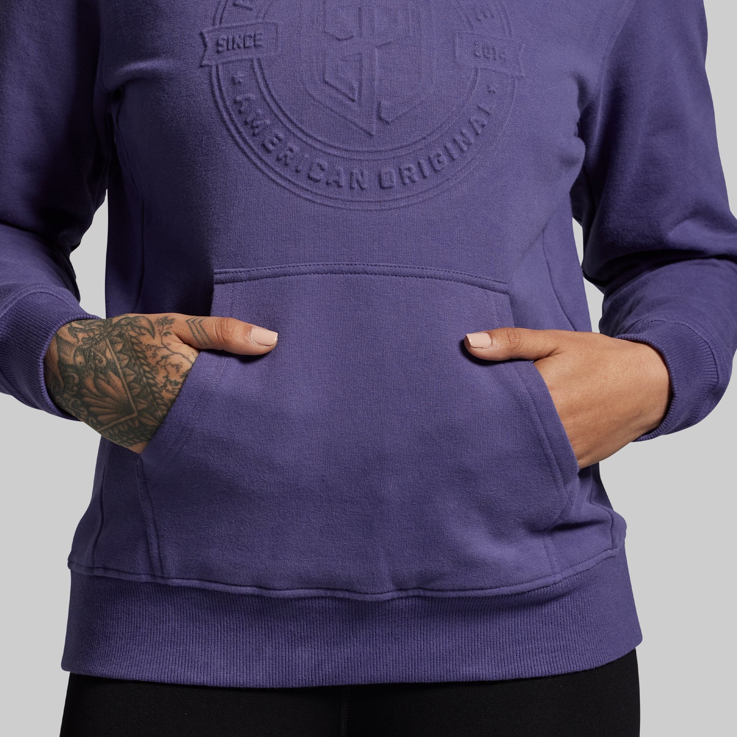 Purple hoodie with a logo on the chest against a gray background