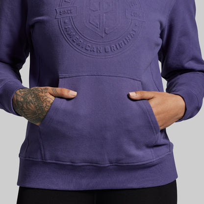 Purple hoodie with a logo on the chest against a gray background