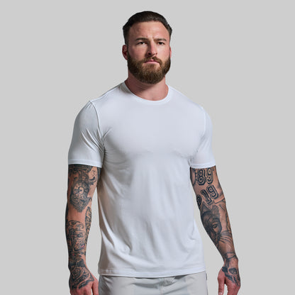 Man wearing a plain white t-shirt against a light gray background