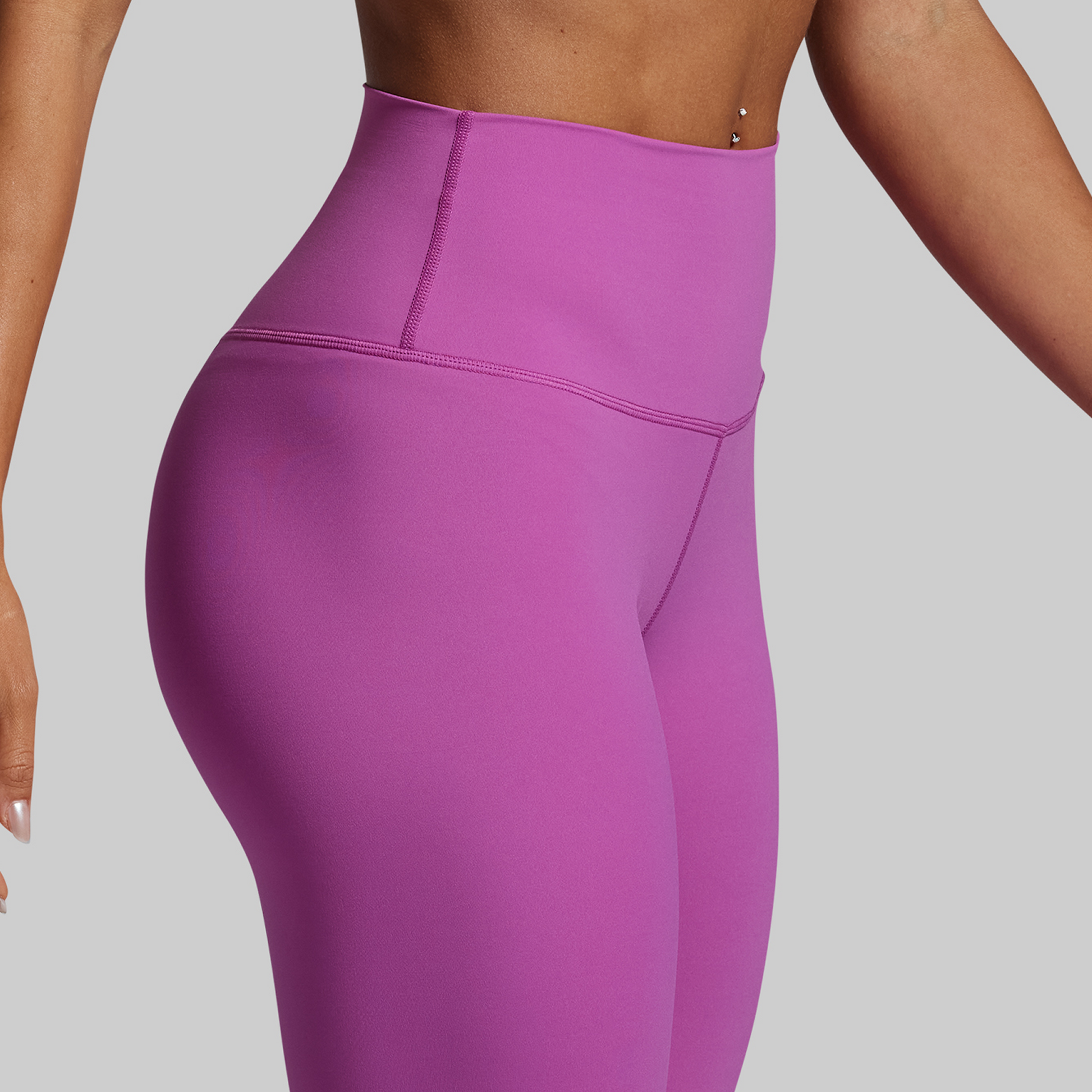 Purple leggings worn by a person on a gray background