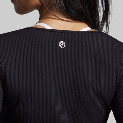 Black ribbed long-sleeve shirt with a logo on the chest against a neutral background