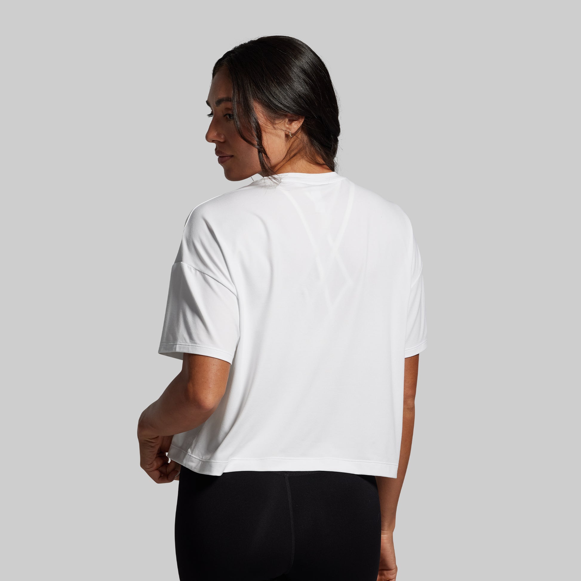 Person wearing a white t-shirt on a plain background