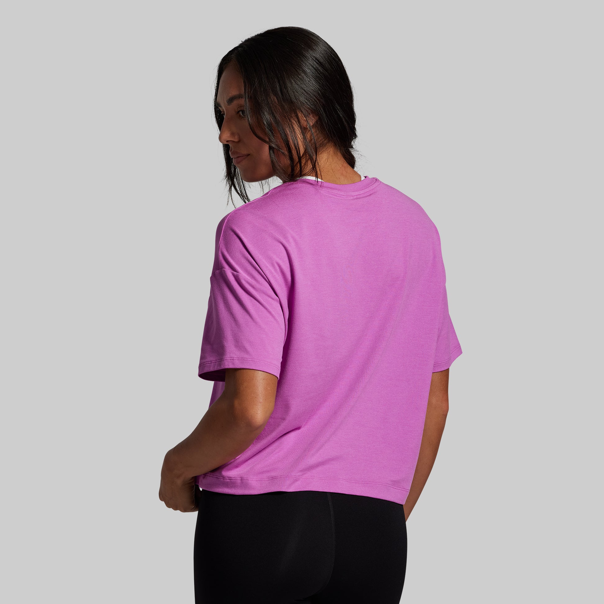 Person wearing a purple t-shirt on a plain background