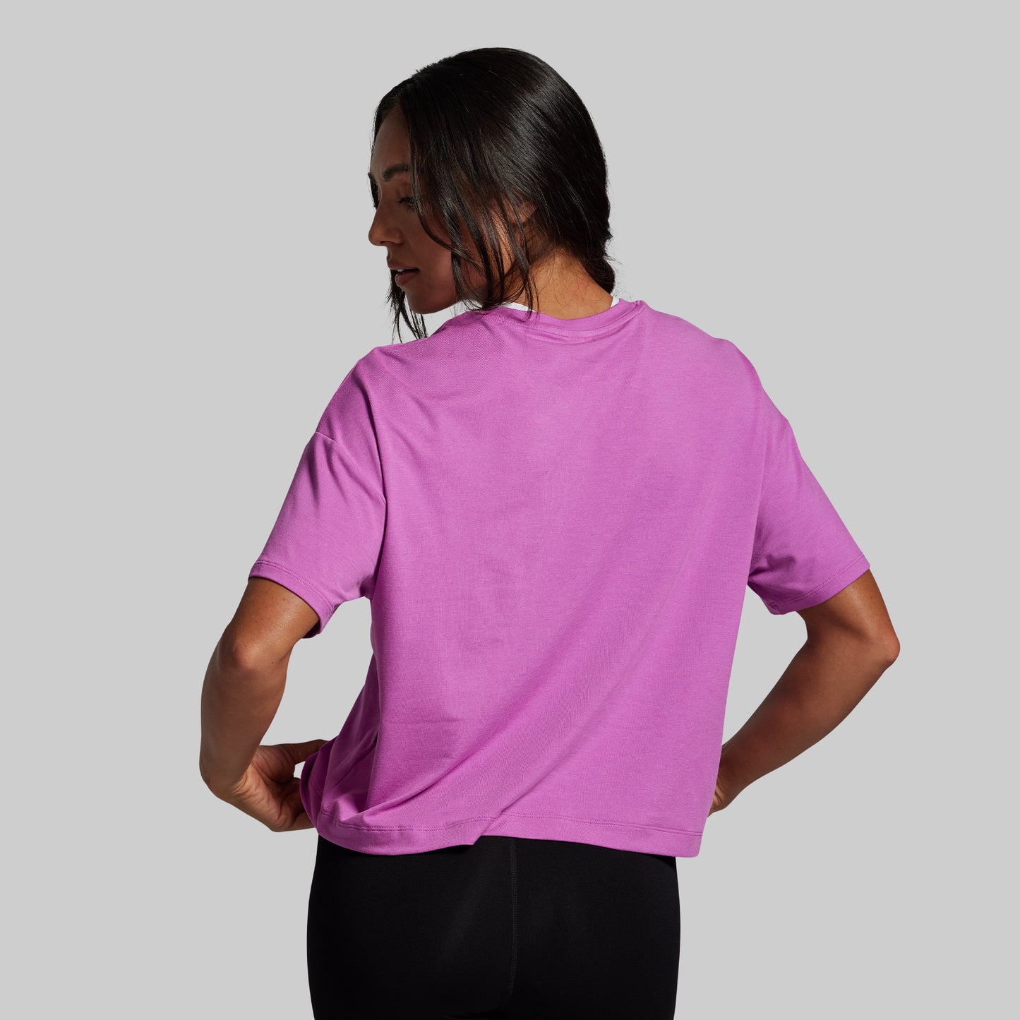 Person wearing a purple t-shirt on a gray background