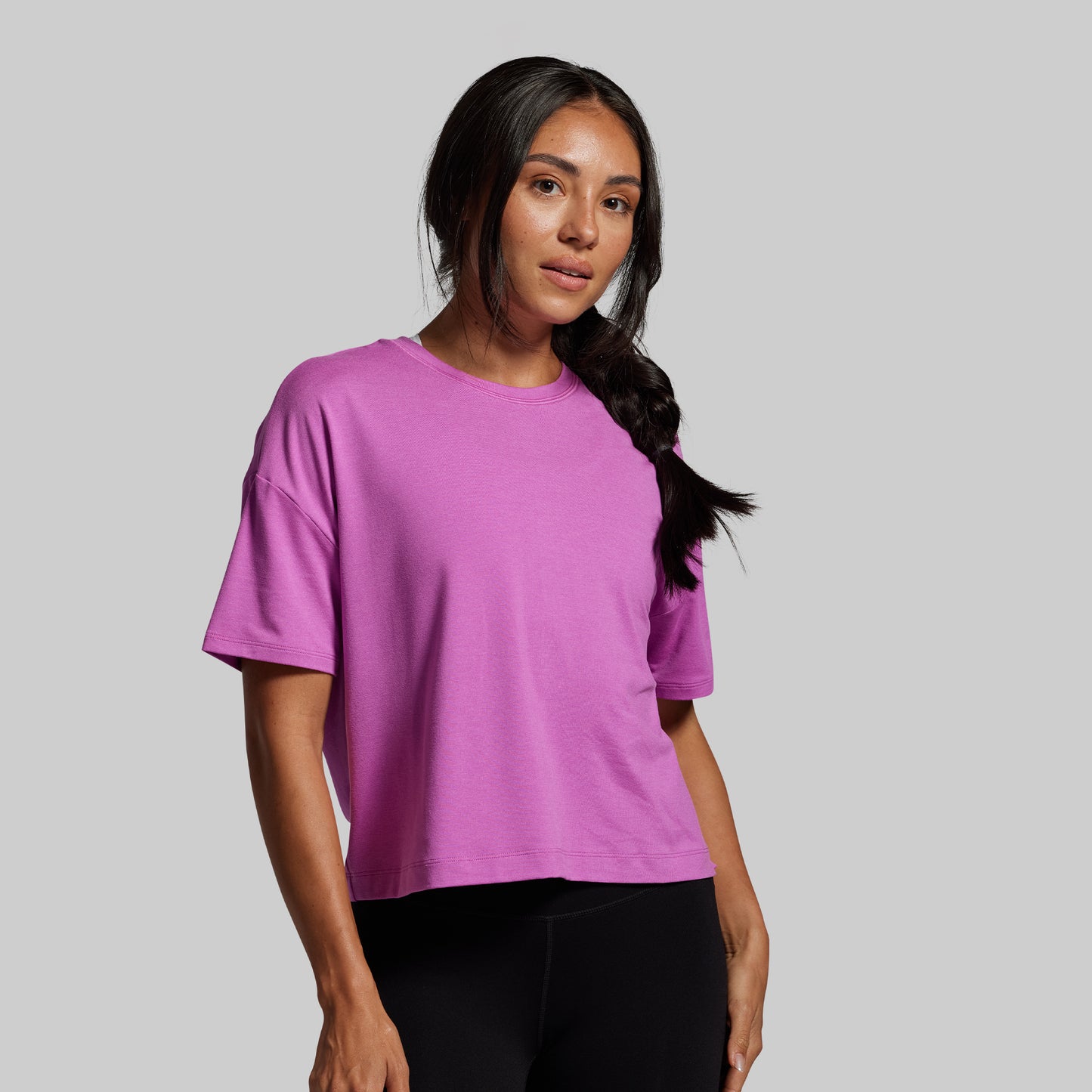 Woman wearing a purple t-shirt against a gray background