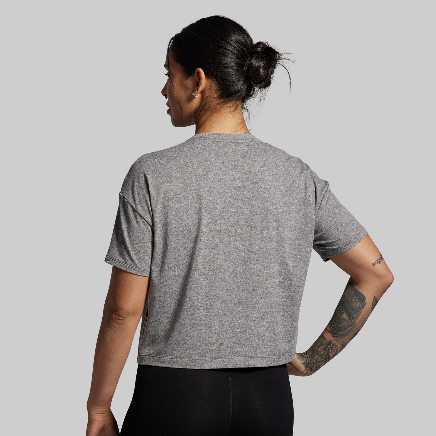 Person wearing a gray t-shirt on a plain background