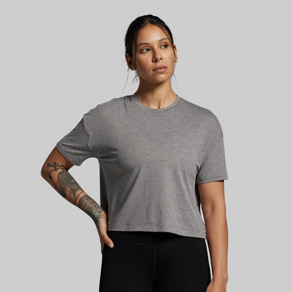 Woman wearing a gray t-shirt against a plain background