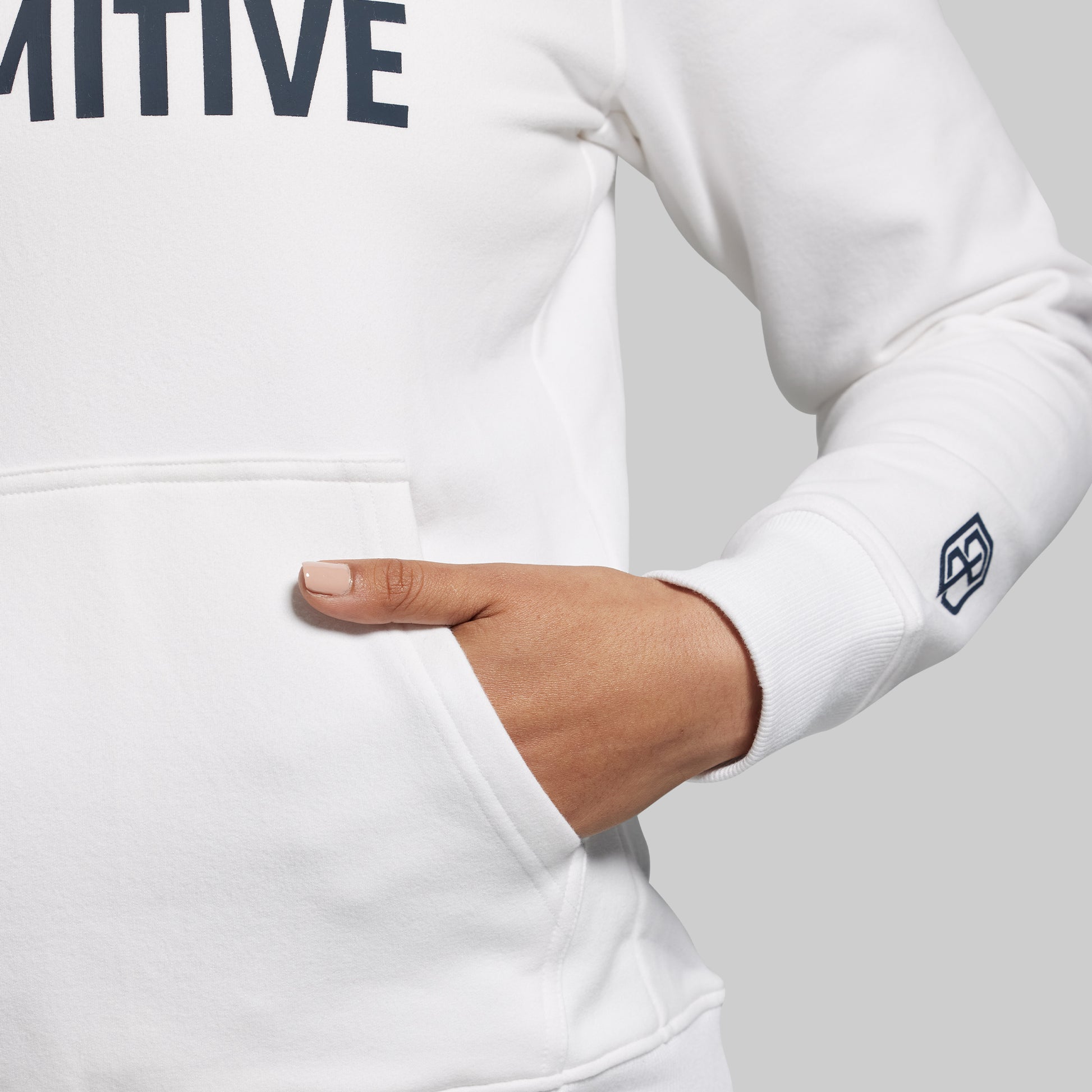 White sweatshirt with brand logo on sleeve against a neutral background