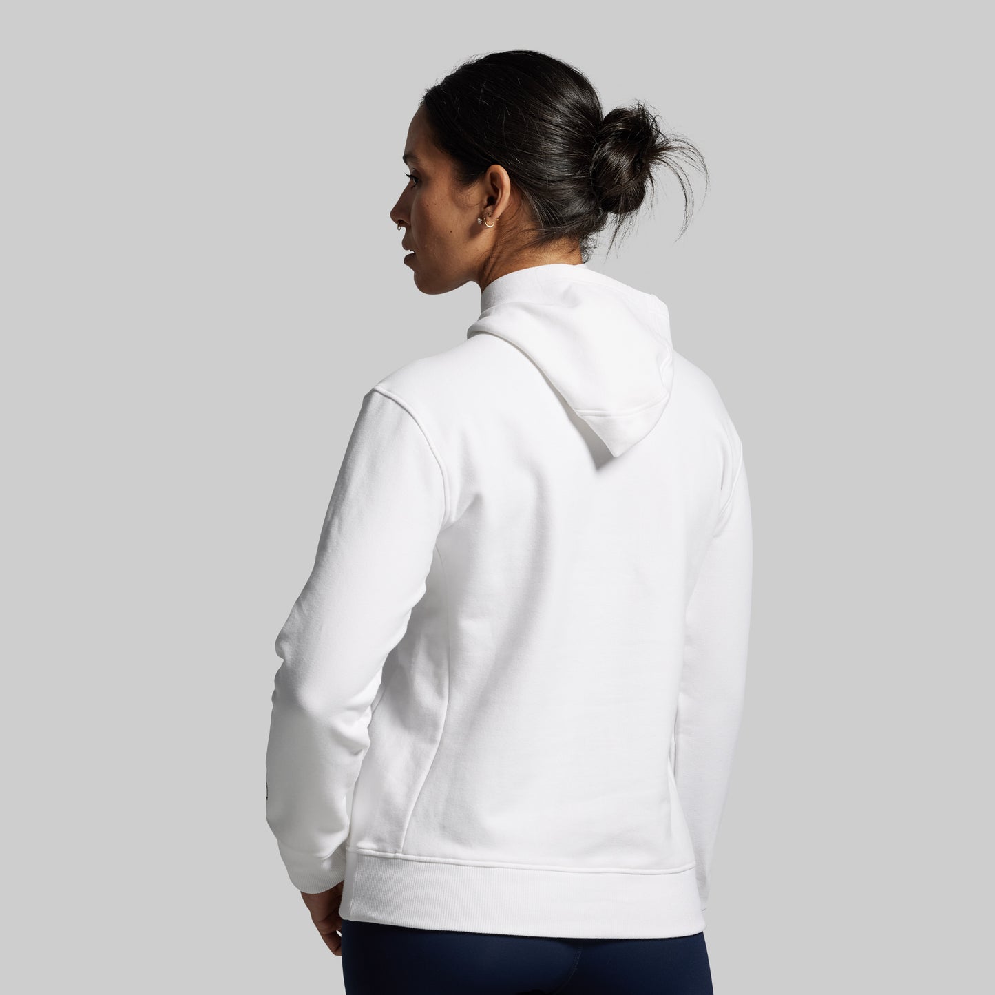 Person wearing a white hoodie on a plain background