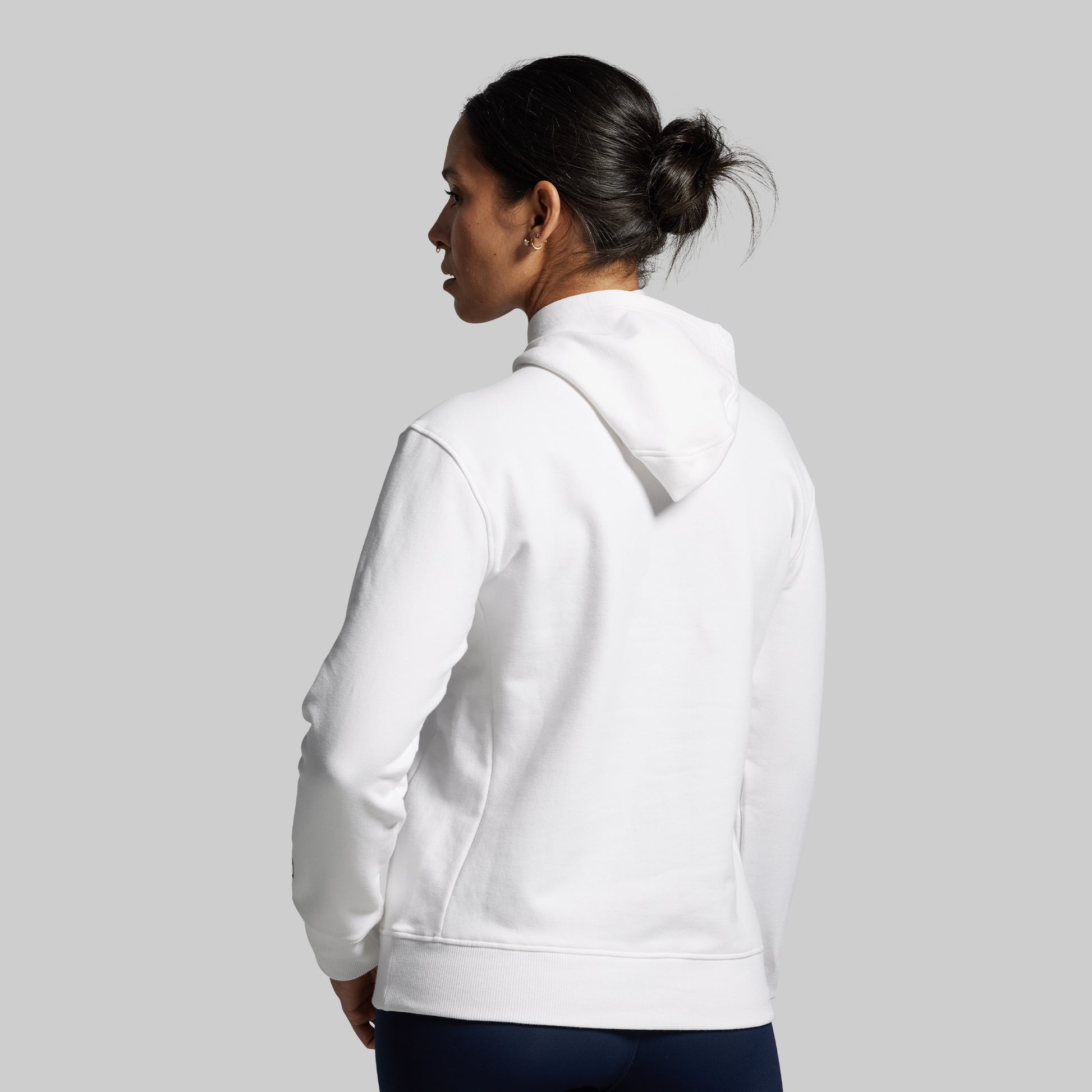 Person wearing a white hoodie on a plain background