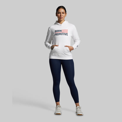 Person wearing a white hoodie with 'Born Primitive' logo and navy leggings on a gray background