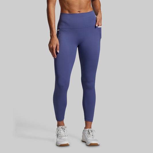 Person wearing blue leggings on a gray background