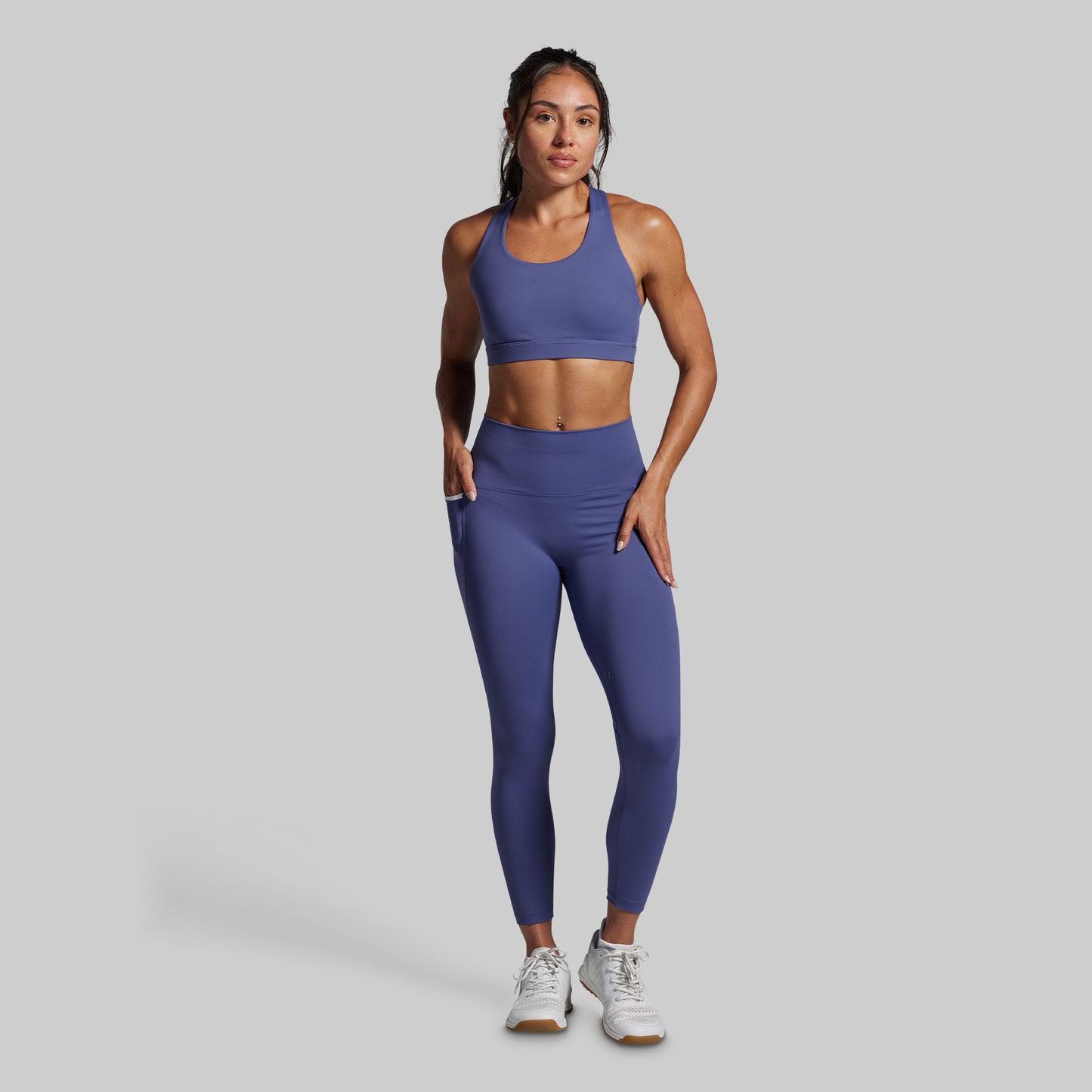 Woman wearing a blue athletic outfit on a gray background