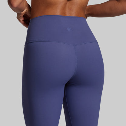 Blue leggings worn by a person on a gray background