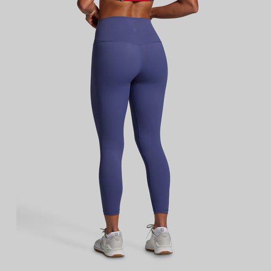 Person wearing purple leggings on a gray background