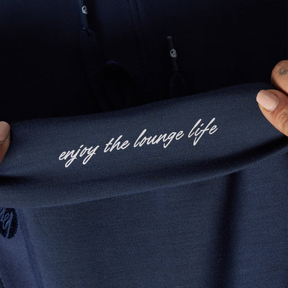 Navy blue garment with 'enjoy the lounge life' text held by a person.