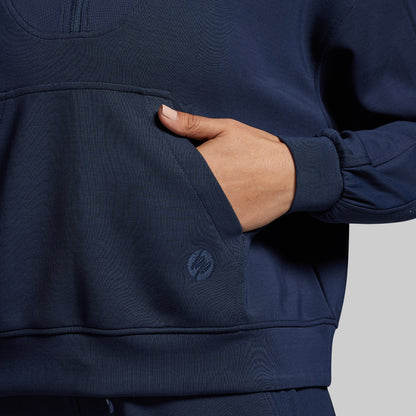 Navy blue pullover with a brand logo on a gray background