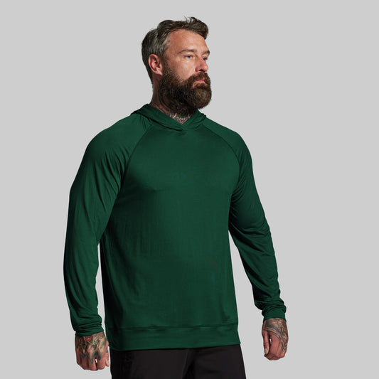Man wearing a green hoodie against a gray background
