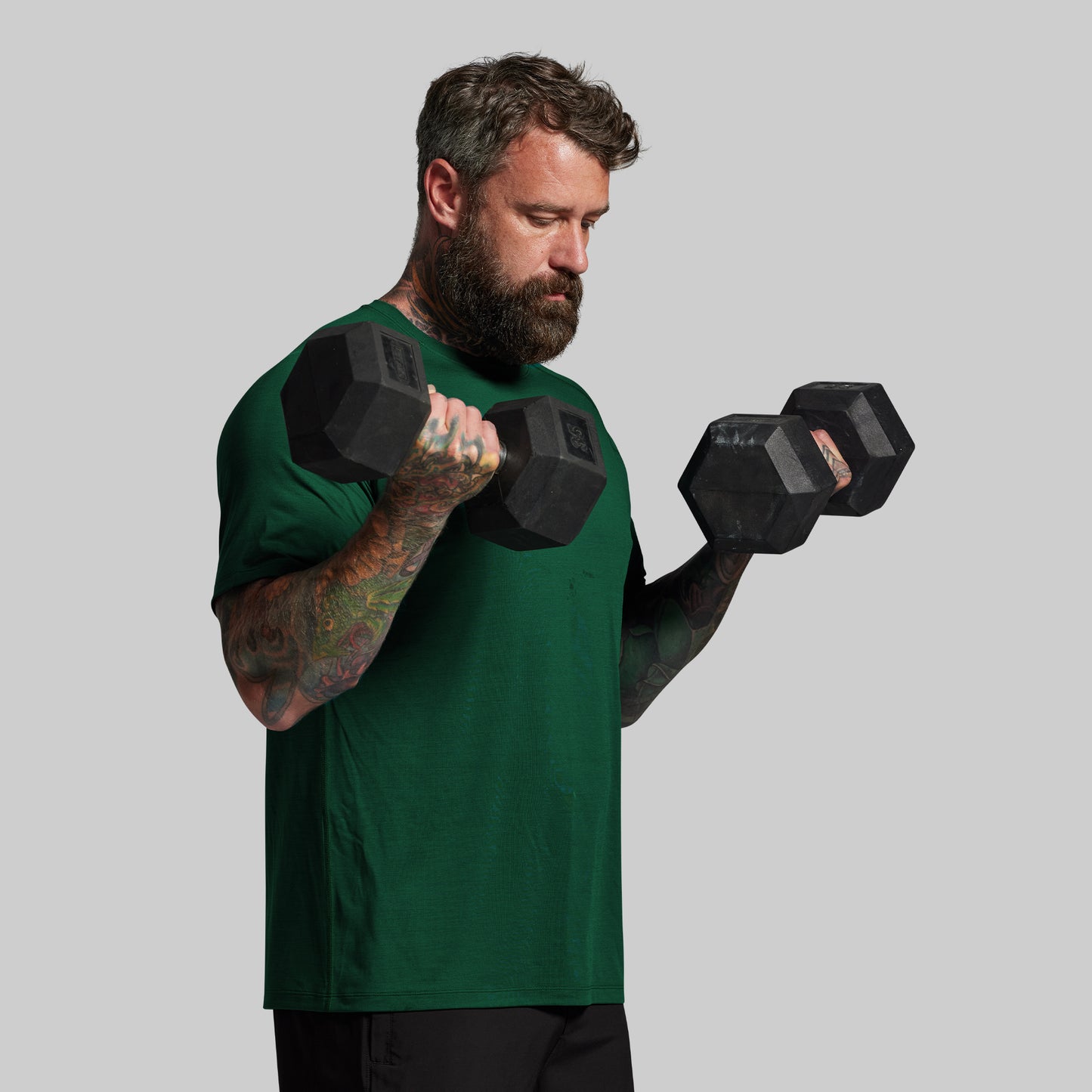 Man lifting dumbbells against a plain background