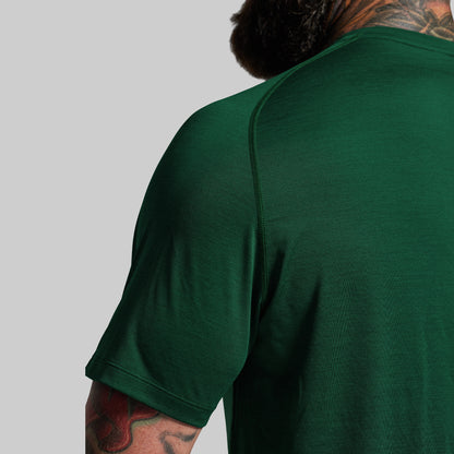 Person wearing a green t-shirt with a plain background