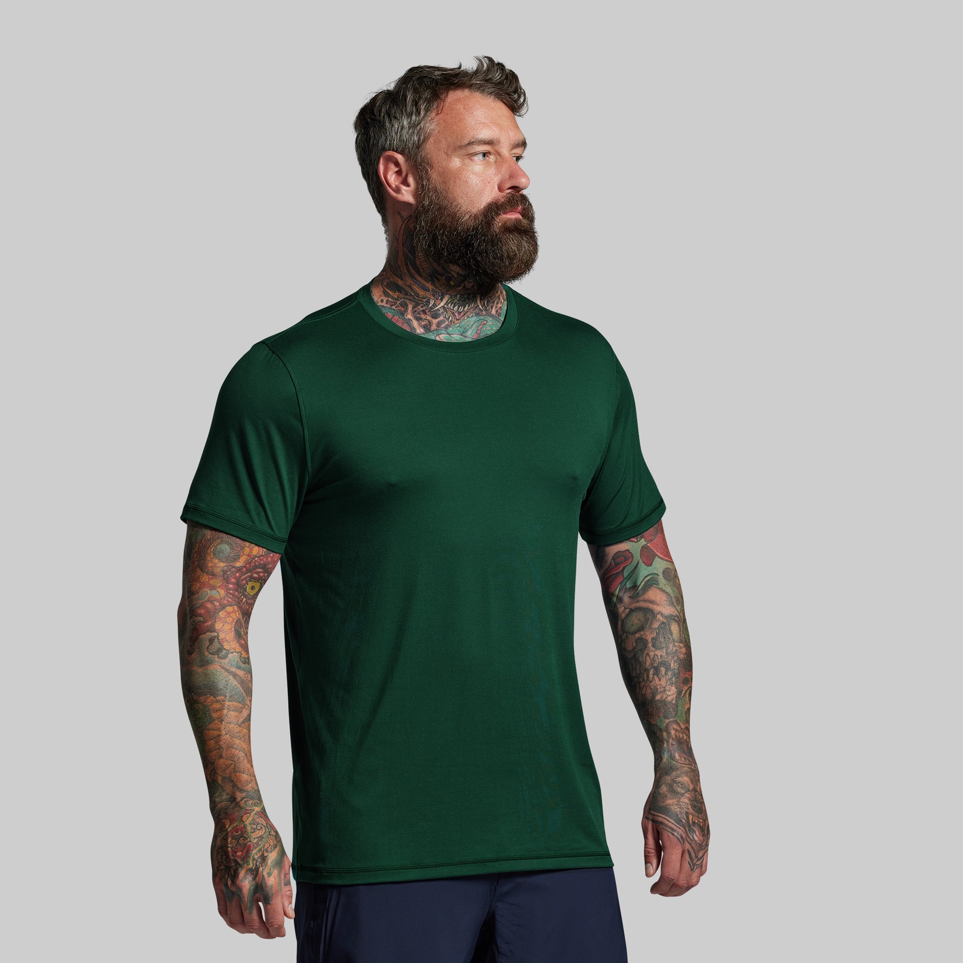 Man wearing a green t-shirt against a gray background